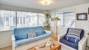 A living room with a blue sofa, a wooden coffee table, and a floor lamp. - Quaint Avalon Cottage < Half-mi to Beaches! (Avalon)