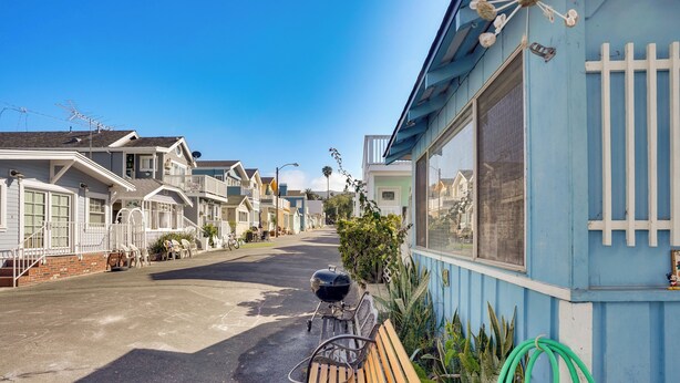 A row of beach houses with a wooden bench and a barbecue grill in the foreground. - Quaint Avalon Cottage < Half-mi to Beaches! (Avalon)