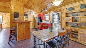 A wooden cabin interior with a kitchen, dining area, and bar. - Broken Bow 'starlight Cabin' w/ Private Hot Tub! (Broken Bow)