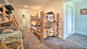 A bunk bed room with a ladder, a door, and a dartboard on the wall. - Rustic & Modern Russell Cabin w/ Grill + Deck (Russell)