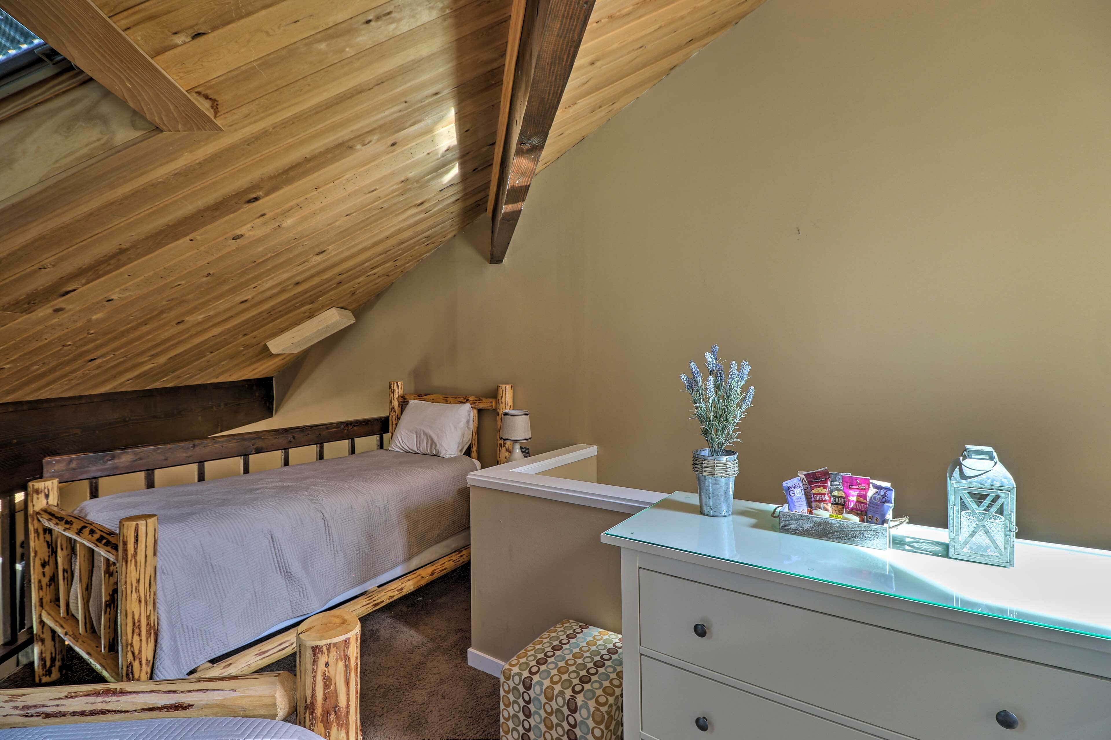 Une chambre à coucher avec un lit en bois, une commode blanche et une petite fenêtre.