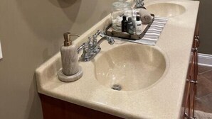 Une salle de bain avec deux lavabos, un miroir et un meuble-lavabo.