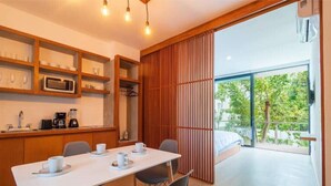 Une cuisine moderne avec un coin repas, une grande fenêtre et une vue sur la verdure.