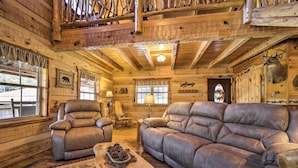 A log cabin interior with a leather sofa, armchairs, and a rustic wooden floor. - Stunning Creekside Cosby Cabin w/ Deck + Fire Pit! (Cosby)