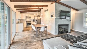 Eine moderne Küche mit Essbereich, Kamin und Wand-Fernseher.
