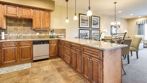 A kitchen with wooden cabinets, a dishwasher, granite countertops, and pendant lighting. - Branson Condo w/ Pool Access & Views, 3 Mi Dtwn! (Branson)