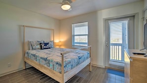 A bedroom with a wooden bed, a ceiling fan, and a window with blinds. - Mexico Beach Home w/ Balcony - Steps to Beach (Port St. Joe)