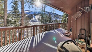 Una terraza de madera con vistas a un paisaje montañoso nevado.
