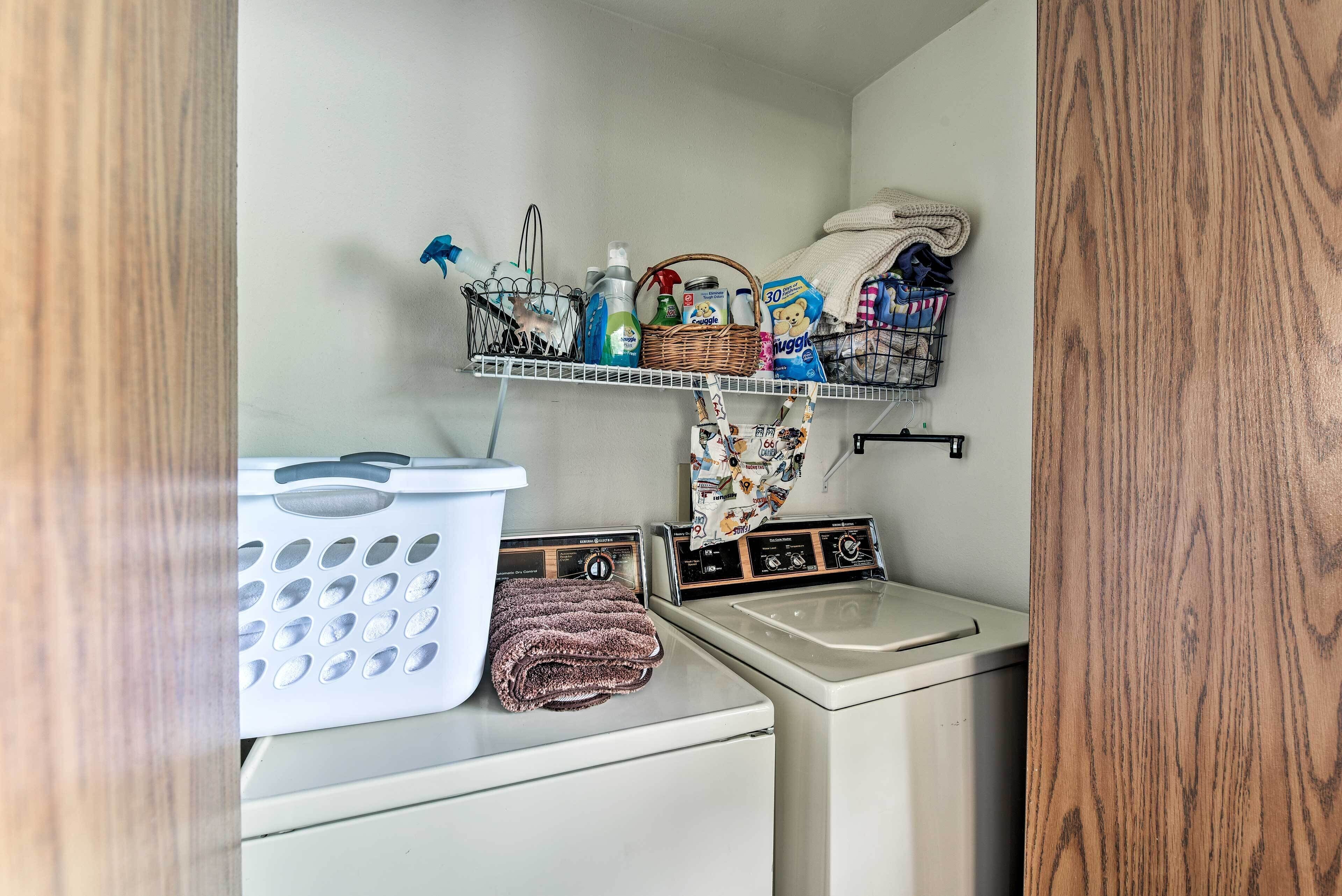 A laundry area with a washing machine, a dryer, and a shelf with cleaning supplies.