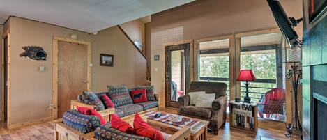 Un salon chaleureux avec des meubles en bois, une cheminée et de grandes fenêtres.