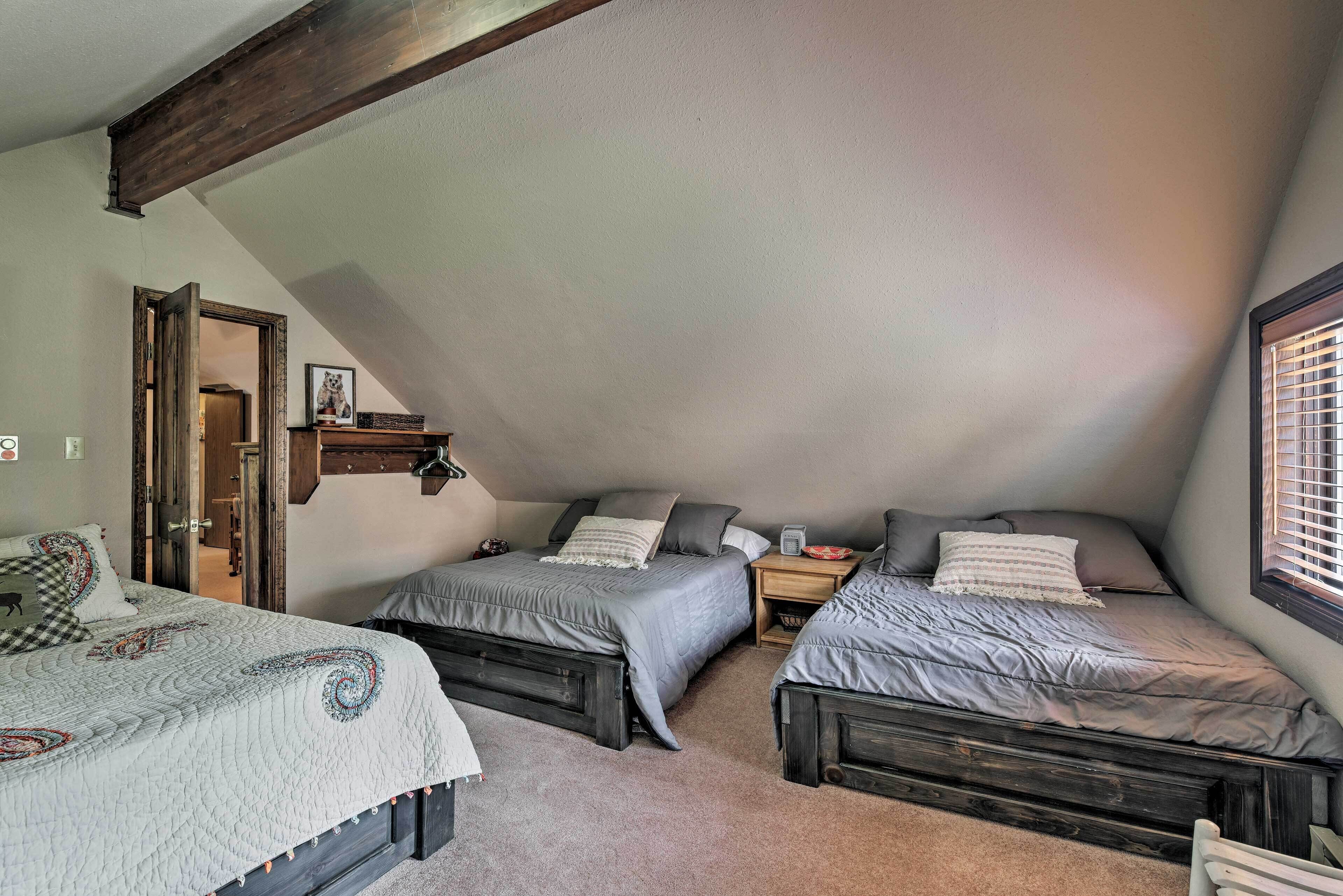 Una camera da letto con due letti, un trave in legno al soffitto e un piccolo finestrino.