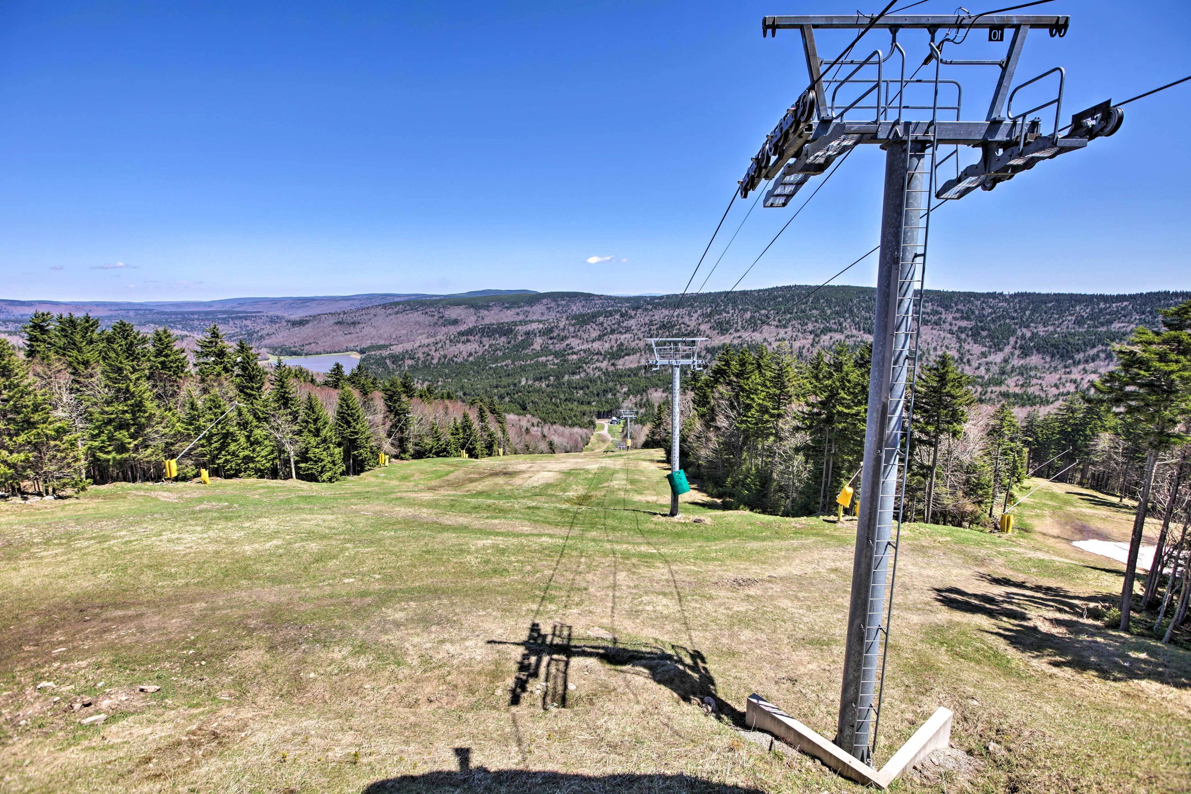 A ski lift with a clear view of the surrounding landscape, including trees and distant hills.