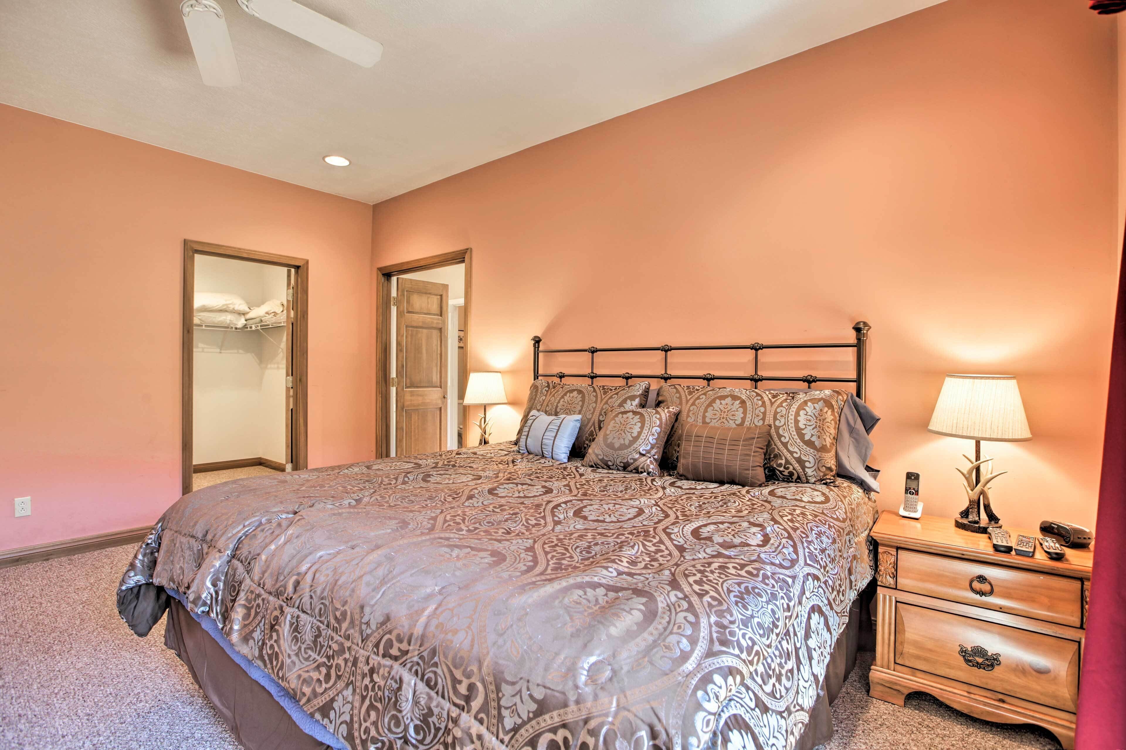A bedroom with a large bed, a nightstand with a lamp, and a wardrobe.