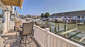 Eine Terrasse mit Sitzgelegenheiten und Blick auf eine Marina mit Booten.