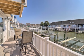 Terraza con mobiliario exterior y vista a un puerto deportivo con barcos.