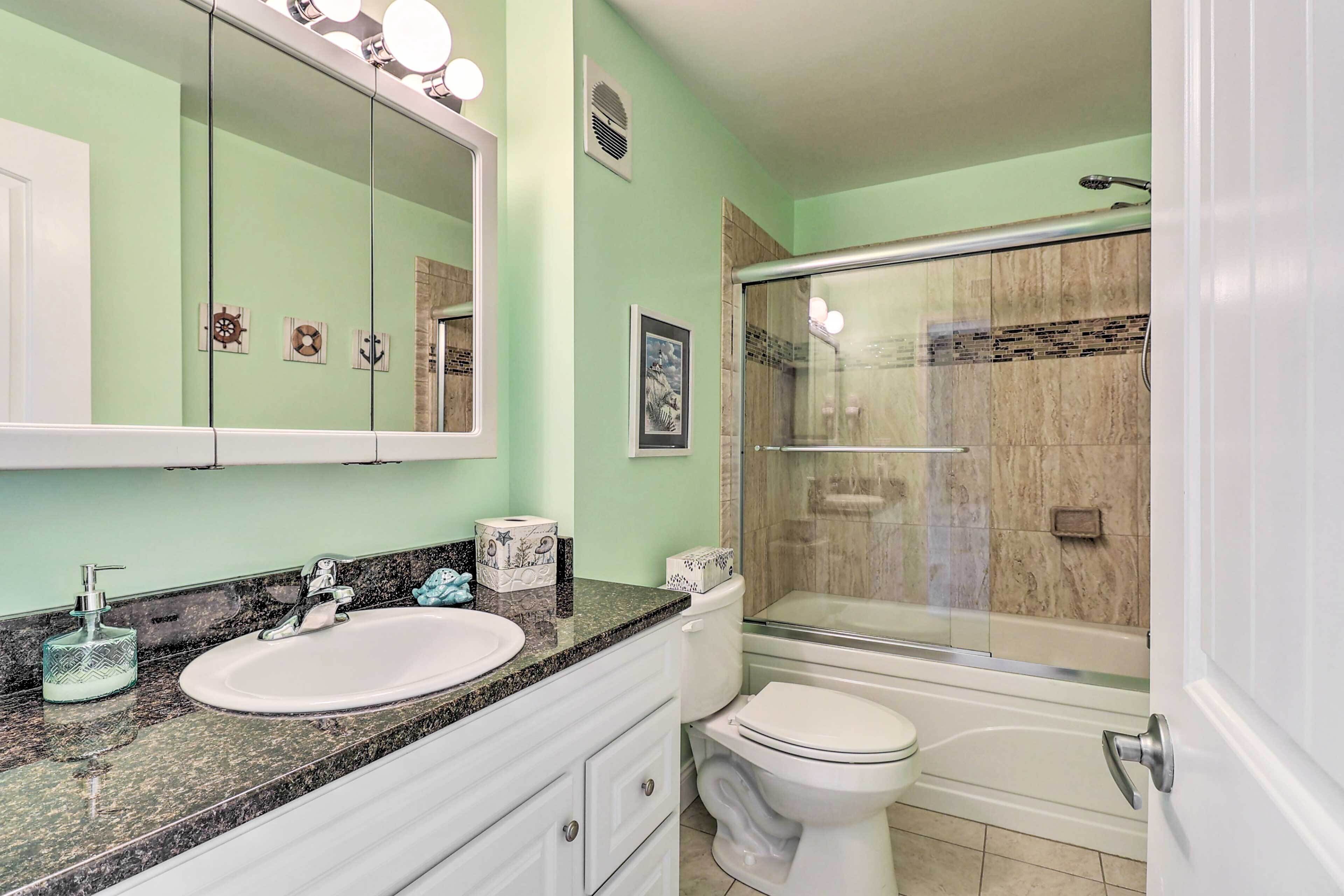 A bathroom with a sink, toilet, and glass-enclosed shower.