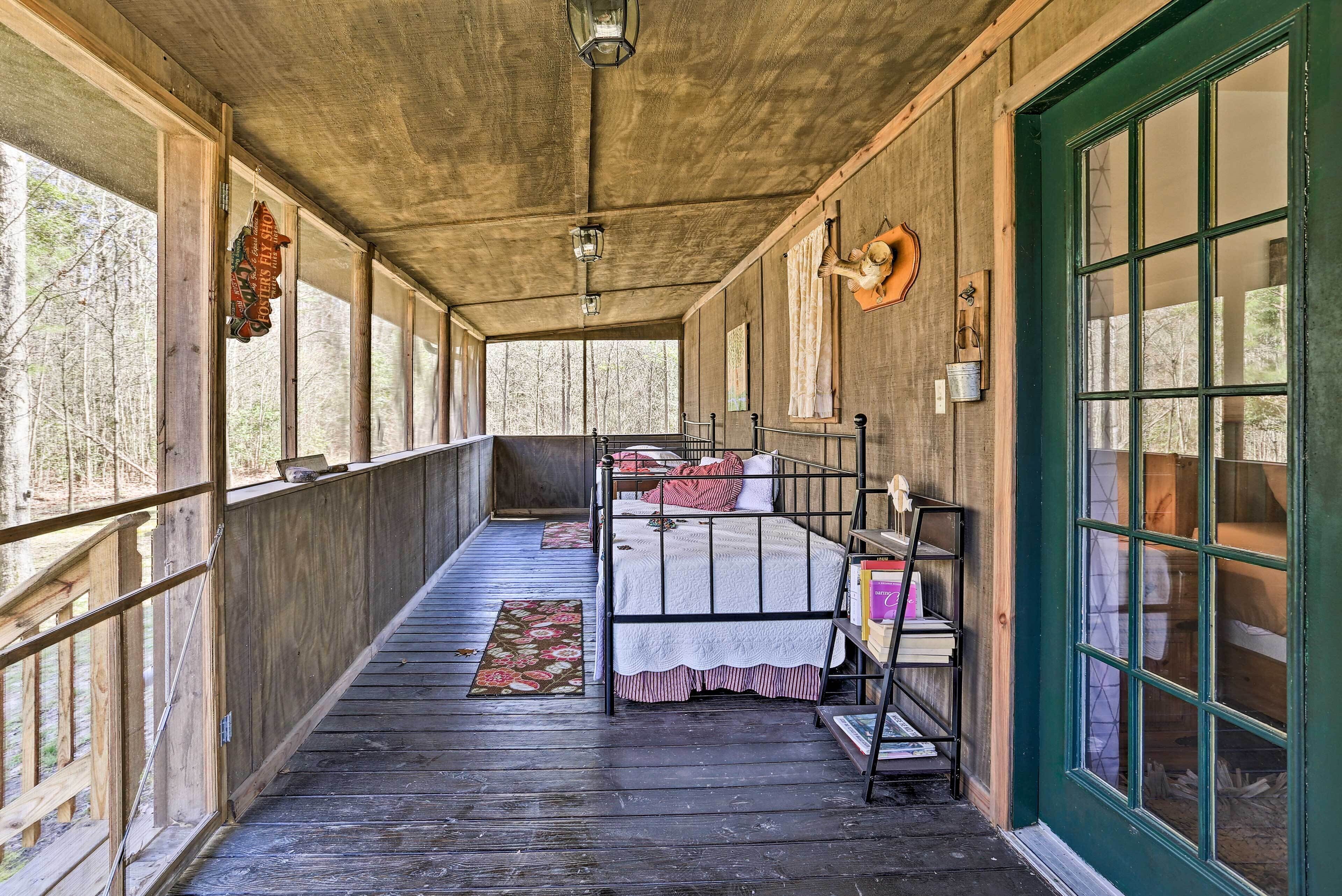 A wooden cabin with a bunk bed, a wooden porch, and a large window.