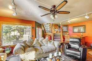 A cozy living room with a sofa, a leather chair, a ceiling fan, and a staircase leading to an upper level. - Beautiful Remodeled Mountain Home in Deer Valley! (Park City)