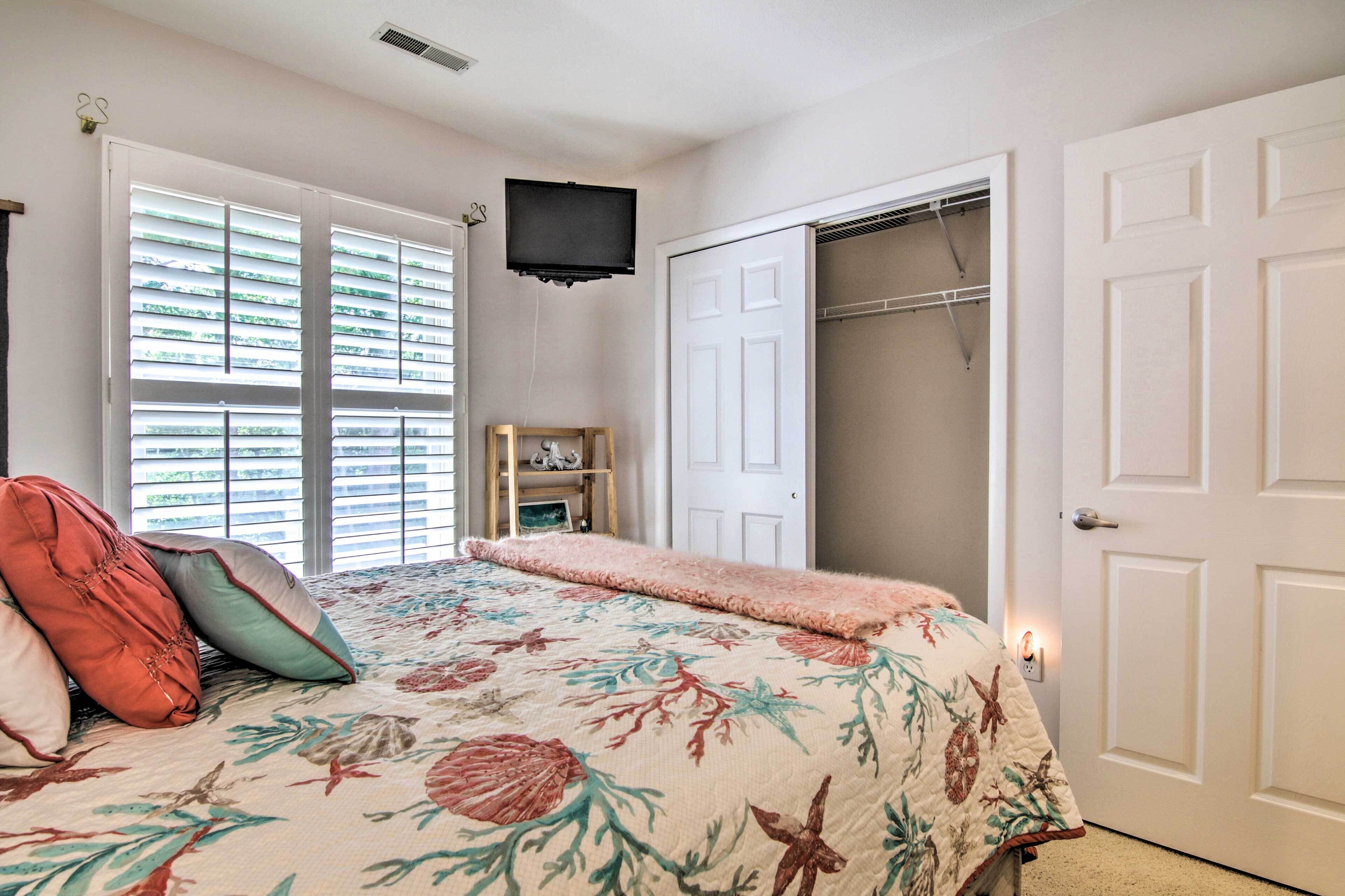 A bedroom with a bed, a closet, and a television.