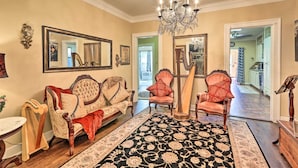 A spacious living room with a large chandelier, a grand piano, and a harp. - Walk to Midwestern State: Wichita Falls Cottage! (Wichita Falls)