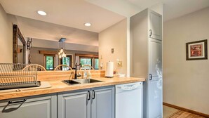 A modern kitchen with grey cabinets, a dishwasher, and a wooden countertop. - Family-friendly Stratton Gem Close to Slopes! (Stratton)