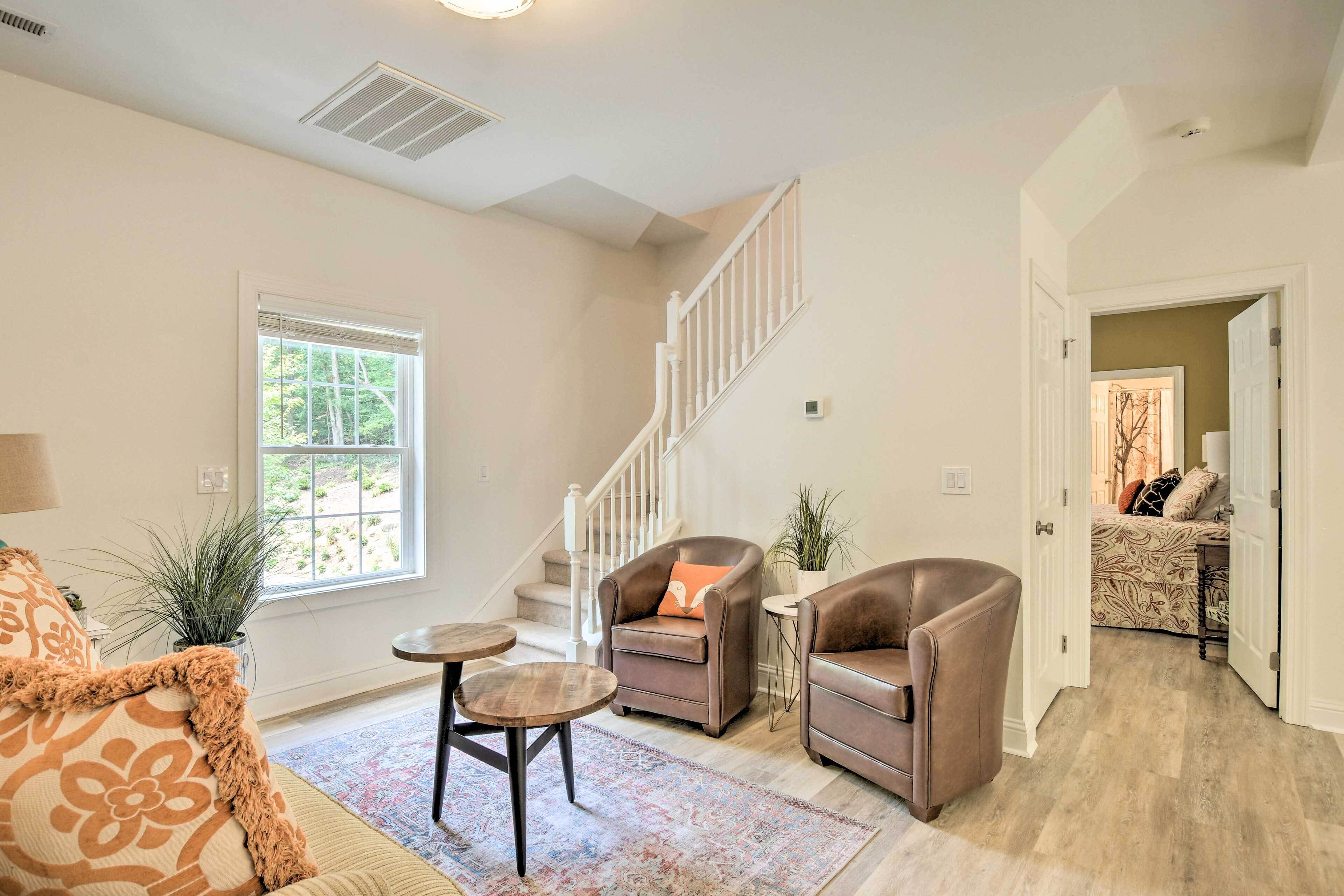 A living room with a staircase, a sofa, a coffee table, and a rug.