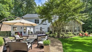A patio area with outdoor furniture, a dining table, and a large umbrella.