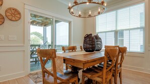 A dining area with a wooden table and chairs, a woven basket centerpiece, and a ceiling light fixture. - 3 Decks & Beach Access: Hilton Head Home (Hilton Head Island)