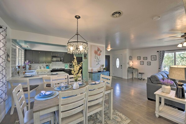 A modern kitchen with a dining area, a living room with a sofa and a coffee table, and a view of the outdoors. - Wine Lovers Garden Oasis in Sutter Creek! (Sutter Creek)