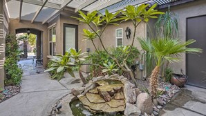 A covered outdoor area with a rock garden, plants, and a bench. - Indio Home w/ Resort Amenities, Near Festivals! (Indio)