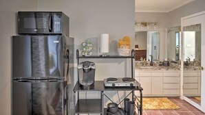A compact kitchen with a refrigerator, microwave, coffee maker, and a small stove. - ~ 10 Mi to Downtown: Quiet Dallas Studio (Dallas)