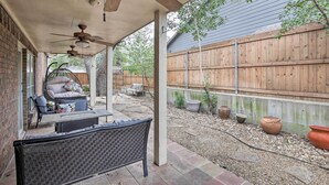 A covered patio area with a ceiling fan, outdoor seating, and a wooden fence in the background. - ~ 10 Mi to Downtown: Quiet Dallas Studio (Dallas)