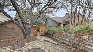 A stone pathway leading to a wooden gate, surrounded by a brick wall and trees. - ~ 10 Mi to Downtown: Quiet Dallas Studio (Dallas)