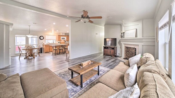 A spacious living room with a wooden coffee table, beige sofas, and a fireplace. - Eufaula Escape w/ Deck - Steps to Lake! (Eufaula)