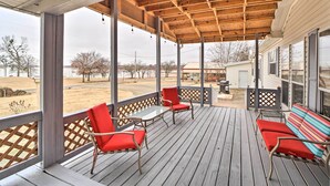A covered porch with wooden beams, red chairs, and a table. - Eufaula Escape w/ Deck - Steps to Lake! (Eufaula)