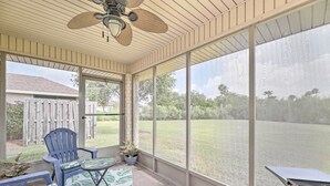 A covered patio with a ceiling fan, large windows, and outdoor seating. - Laguna Vista Home w/ Resort Perks Near Beach! (Port Isabel)