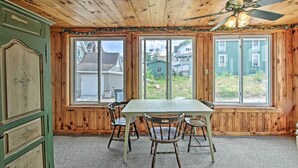Un comedor con techo de madera, una mesa y cuatro sillas.