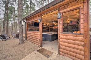 A rustic cabin with a hot tub, wooden deck, and outdoor seating. - Cabin w/ Hot Tub & Grill - 6 Mi to Broken Bow Lake (Broken Bow)