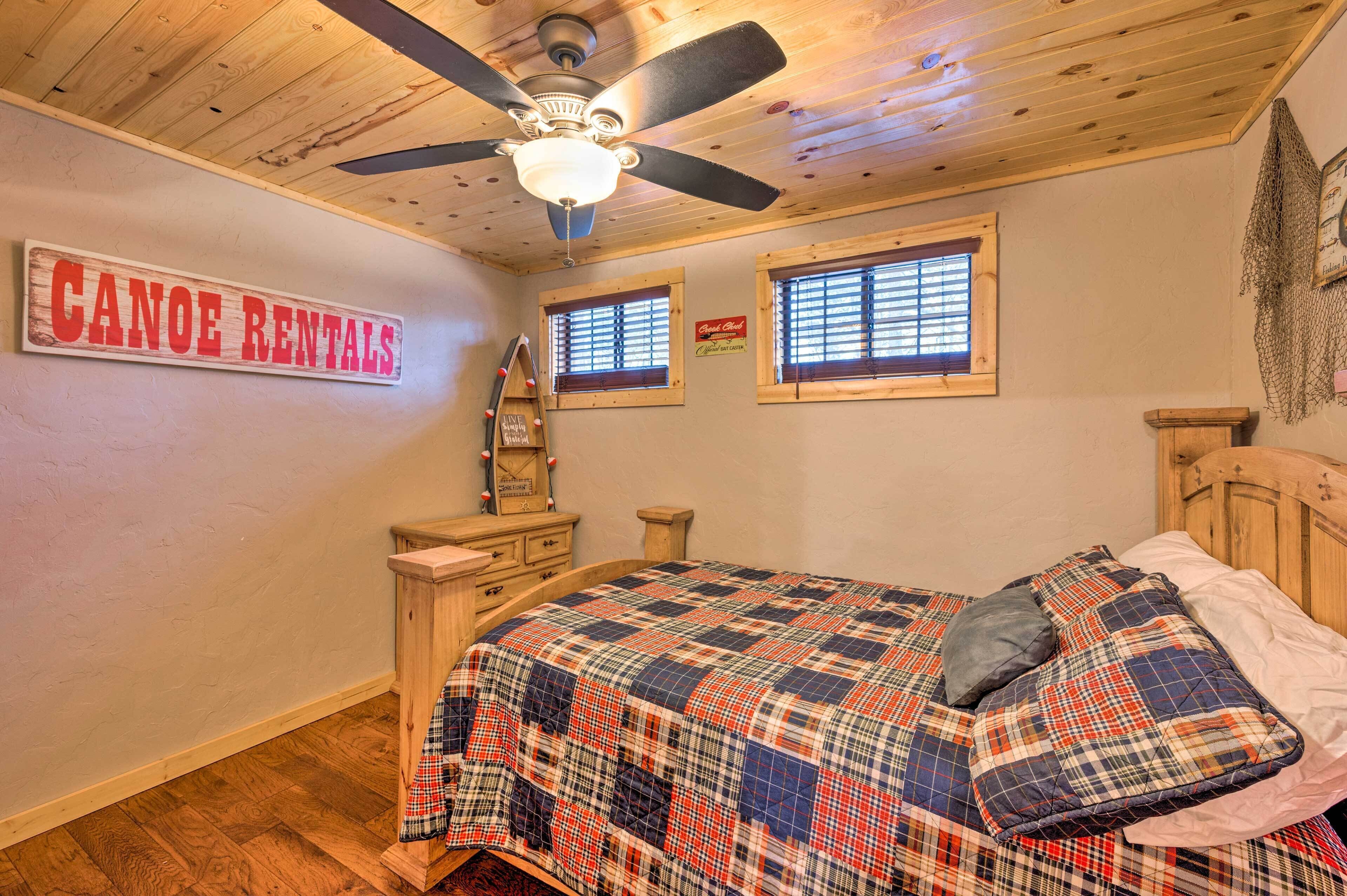 Een slaapkamer met een bed, een plafondventilator, houten wanden en een bord met informatie over het huren van canoes.