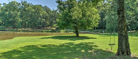 Ein Park mit Teich, Schaukeln und einem Picknicktisch.