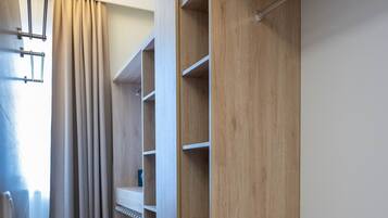 A hallway with wooden flooring and built-in shelving units.