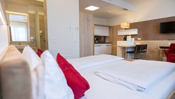 Une chambre d’hôtel comprenant un lit, un bureau, une chaise, une télévision et une salle de bain.