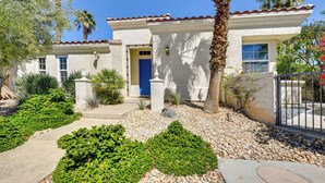 A two-story house with a white exterior, a blue door, and a tiled roof. - Pool & Hot Tub Access: La Quinta Vacation Home (La Quinta)