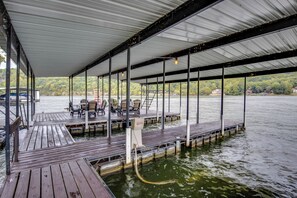 Eine überdachte Anlegestelle mit Holzplanken, Metallgeländern und einer Wasserpumpe.