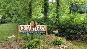 Señal de Cedar Glen Condominiums rodeada de abundante vegetación.
