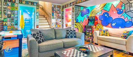 A living room with a sofa, coffee table, and a wall covered with movie posters.