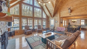 A spacious log cabin interior with large windows, a fireplace, and a variety of seating arrangements. - Grand 4,000 Sq Ft House - 11 Miles to Lancaster! (New Providence)