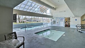 An indoor swimming pool with a skylight, a fire exit sign, and a no lifeguard on duty sign. - Oceanfront Garden City Beach Condo For Families! (Murrells Inlet)