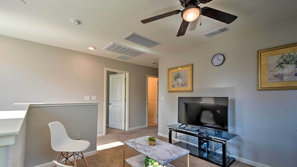 A modern living room with a ceiling fan, a flat-screen TV, a marble coffee table, and a dining area with white chairs. - 4 Mi to City Center: Family-friendly Retreat! (Merced)