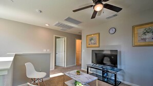 A modern living room with a ceiling fan, a flat-screen TV, a marble coffee table, and a dining area with white chairs. - 4 Mi to City Center: Family-friendly Retreat! (Merced)